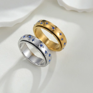 Draaibare roestvrijstalen ringen in goud en zilver met blauwe steen en sterrengravures