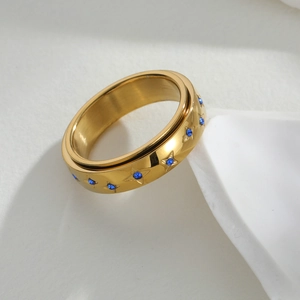 Draaibare gouden roestvrijstalen ring met sterren en blauwe zirkoon op standaard