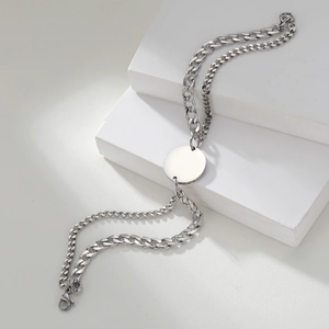 Minimalist double-layer stainless steel Cuban link bracelet with round pendant on white steps