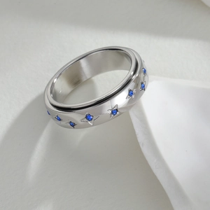 Detail van zilveren spinner ring met sterrengravure en blauwe kristallen inlays