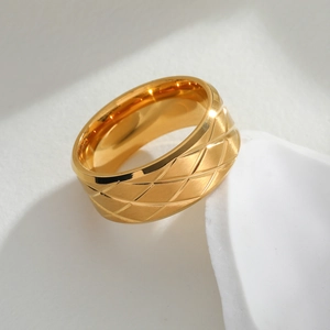 Detail of a wide gold stainless steel ring with elegant quilted pattern and brushed finish