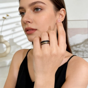 Detailed view of black stainless steel ring with hammered texture and rose gold groove