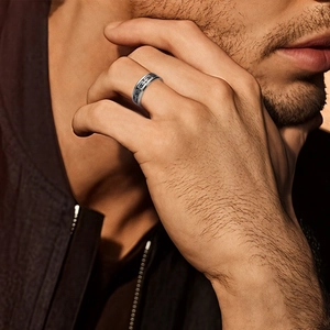 Men's geometric hollow silver ring with black chain pattern on finger close-up view