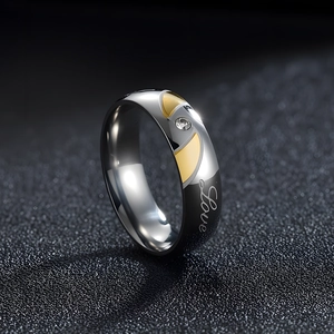 Polished titanium steel ring with Love engraving and small zircon inlay on dark background