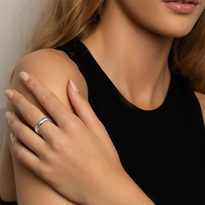 Macro shot of silver titanium ring with diamond inlay worn on a model's hand