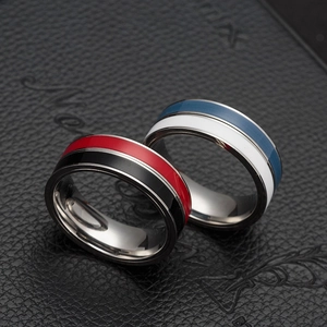 Detail view of red-black and blue-white rotating spinner rings on dark leather surface