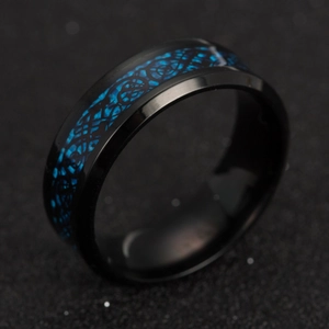 Macro shot of titanium steel men's ring with blue Celtic dragon pattern on black finish