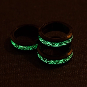 Detailed close-up of three black luminous rings with green glowing dragon patterns