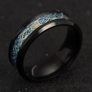 Macro view of men's black titanium ring with blue carbon fiber and Celtic dragon inlay