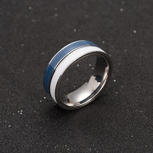 Detail view of a dual-color rotating ring with blue and white enamel and silver metal finish