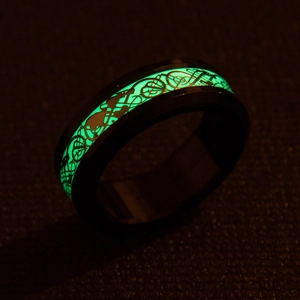 Close-up of glowing green luminous dragon pattern on a black spinner ring for men