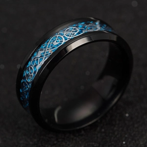 Close-up of black titanium ring featuring blue carbon fiber and silver dragon inlay
