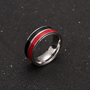 Detail of three-tone spinning ring with red and black stripes on polished titanium steel