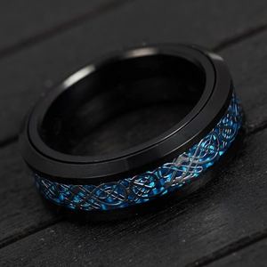 Detail of titanium ring with blue carbon fiber and silver celtic dragon inlay decoration