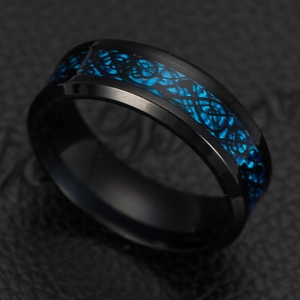 Macro detail of men's black titanium ring featuring blue carbon fiber and Celtic dragon inlay
