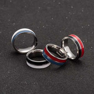 Macro close-up of four spinning stainless steel rings with colorful enamel stripes