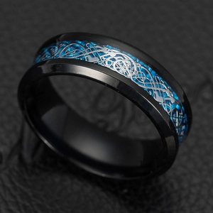 Macro shot of silver dragon inlay over blue carbon fiber on black titanium steel ring band