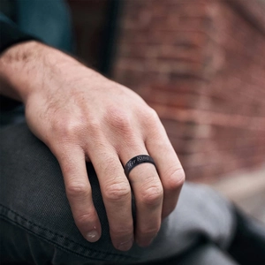 Nahaufnahme eines schwarzen Edelstahlrings für Herren mit Her King Gravur an der Hand