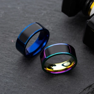 Titanium steel NFC smart rings in deep blue and rainbow gradient finish on stone