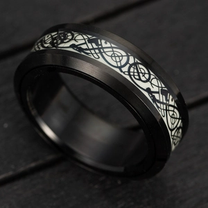 Close-up of black spinner ring featuring luminous band and engraved Viking axes symbols
