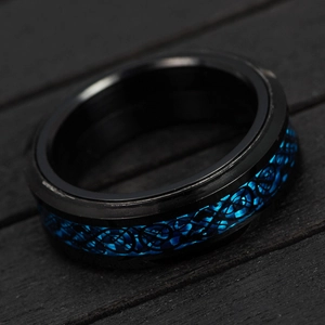 Macro shot of titanium steel men's ring with blue carbon fiber celtic dragon pattern