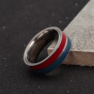 Macro shot of two-tone rotating anxiety ring with red and blue enamel on gunmetal steel