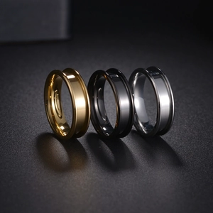 Nahaufnahme von drei gerillten Edelstahlringen in Gold, Schwarz und Silber Finish