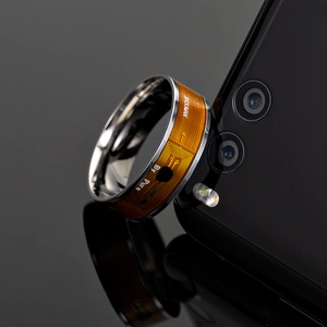 Macro view of NFC smart ring with orange flexible circuit board and silver metal finish