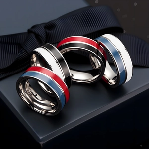 Minimalist spinning stainless steel rings with colorful enamel stripes on a blue gift box