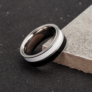 Two-tone rotatable spinner ring in black and white finish on a minimalist stone base