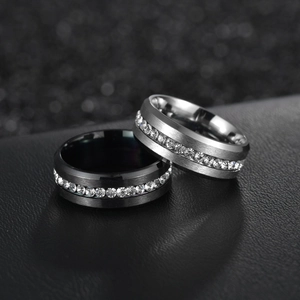 Macro shot of black and silver brushed steel rings with single row cubic zirconia