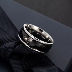 Polished stainless steel ring with black inlay and center zircon on a gift box
