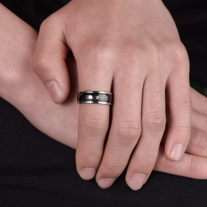 Men's minimalist black and silver stainless steel ring with a round center cubic zirconia