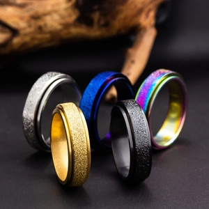 Macro shot of rotating titanium steel rings with frosted texture in multiple metallic colors