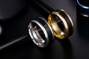 Macro shot of silver and gold temperature rings with Fahrenheit display on black stone