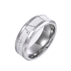 Détail macro d'une bague en acier titane argenté avec finition polie et pierre blanche