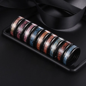 Luminous stainless steel Celtic dragon rings in multiple colors on black display