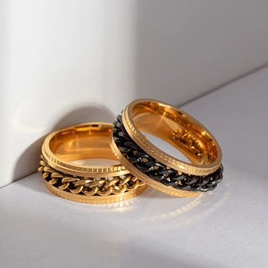 Close-up of golden and black rotating chain stress relief rings in polished steel