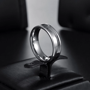 Polierter Edelstahlring mit Nut für DIY-Einlagen auf einem eleganten schwarzen Schmuckhalter
