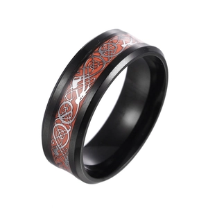 Detail of black stainless steel ring with red Celtic dragon pattern inlay and silver trim