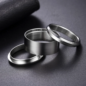 Close-up of three-piece silver ring set with brushed texture and mirror polished edges