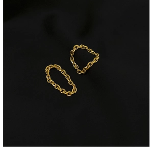 Detailed view of two flexible gold chain rings made of polished stainless steel links