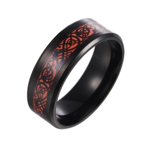 Macro shot of matte black stainless steel ring featuring a red Celtic dragon inlay pattern