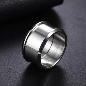 Macro detail of silver wide band ring featuring brushed metal finish and stepped edges