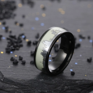 Macro shot of luminous reindeer ring with glowing elk patterns on black titanium steel