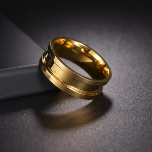 Detaillierte Makroansicht eines vergoldeten Edelstahlrings mit breiter Mittelrille