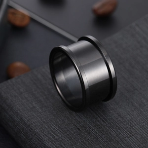 Macro shot of industrial black brushed stainless steel ring setting on a textured background