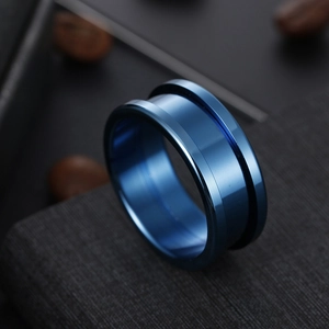 Macro detail of men's wide blue stainless steel ring with industrial triple groove design