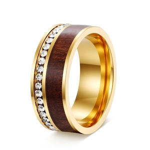 Macro detail of gold ring featuring wood inlay and a single row of sparkling crystals