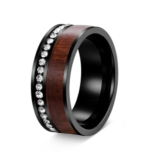 Macro detail of black metal ring featuring acacia wood inlay and crystal zircon accents